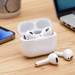 Best wireless earbuds under 200 dollars 2024 displayed near a laptop and phone on desk